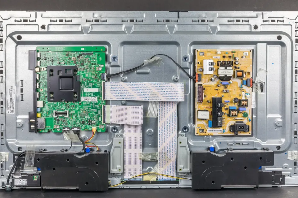 The back of a 40-inch LED-backlit LCD television with its rear cover removed, showing the main board and the power supply board on the metal chassis